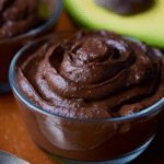 Delicious avocado chocolate mousse in a clear glass, topped with chocolate shavings and mint leaves.