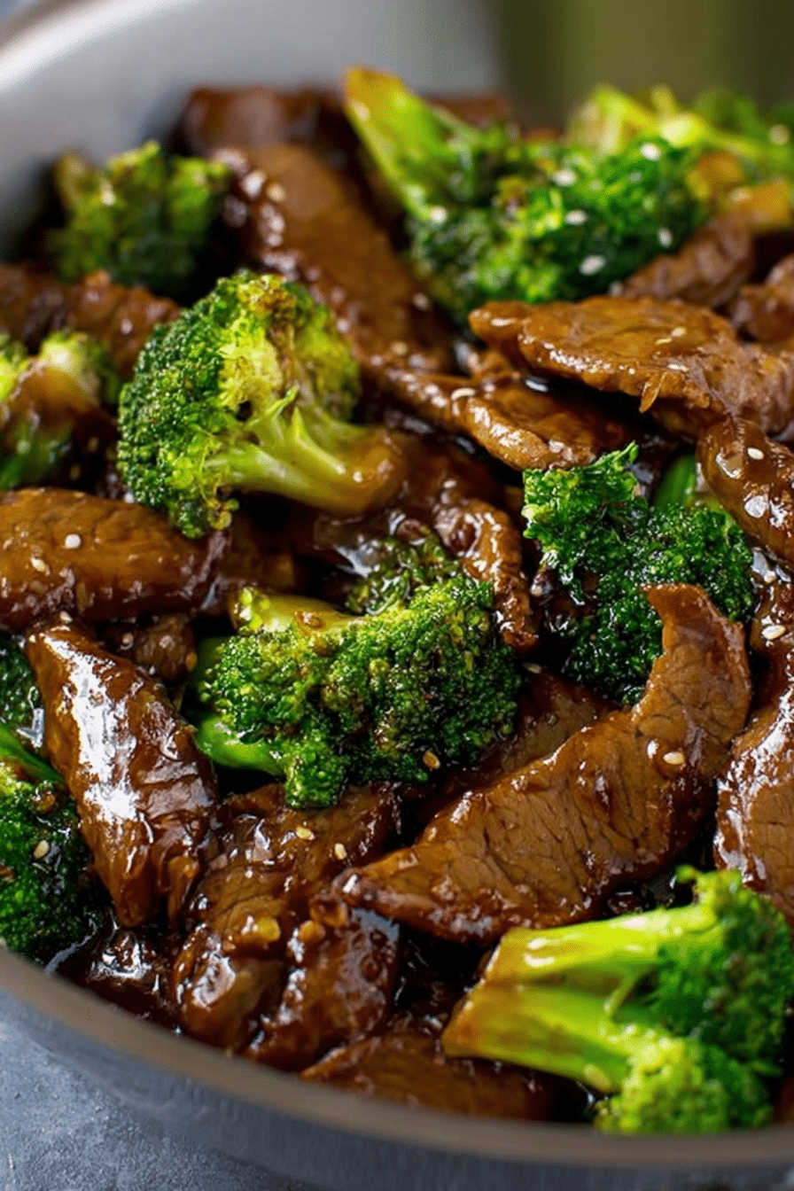 Beef and broccoli stir fry in a bowl with sesame seeds and rice, showcasing a colorful and appetizing dinner dish.