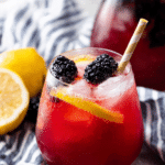Refreshing blackberry lemonade in a glass with ice and garnishes of lemon slices and blackberries.