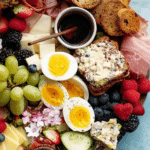 A stunning breakfast charcuterie board with brie cheese, salami, fresh berries, and mini muffins, perfect for brunch.