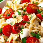 Vibrant caprese pasta salad with tomatoes, mozzarella, and basil in a bowl, perfect for a refreshing summer meal.