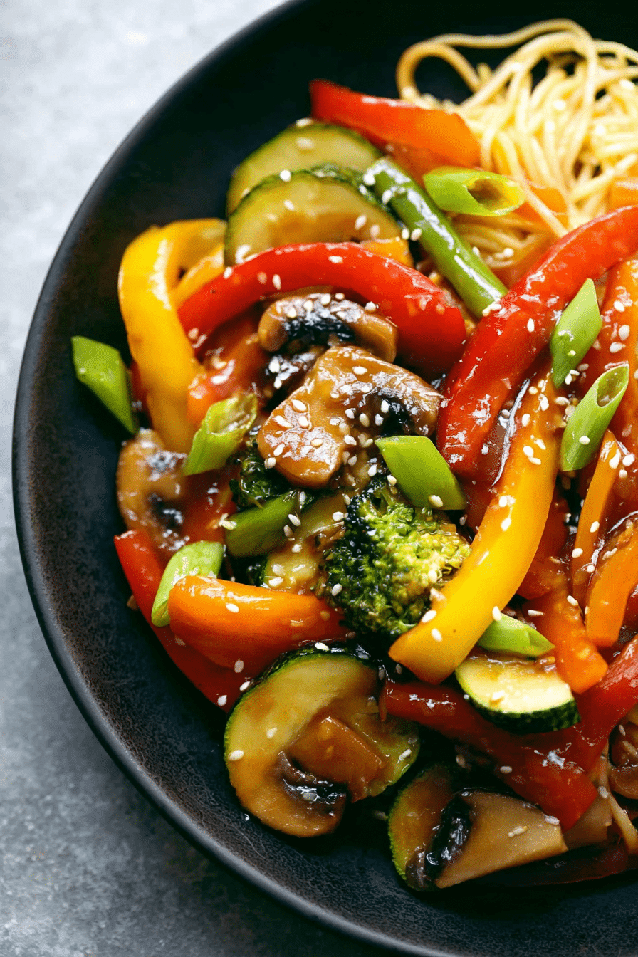 Colorful vegetable stir fry in a wok with bell peppers, broccoli, and carrots, topped with sesame seeds.