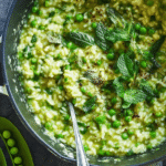 Creamy spring pea risotto with mint and truffle oil in a white bowl