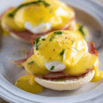 Delicious Eggs Benedict with poached egg, Canadian bacon, and homemade hollandaise sauce on a toasted English muffin.