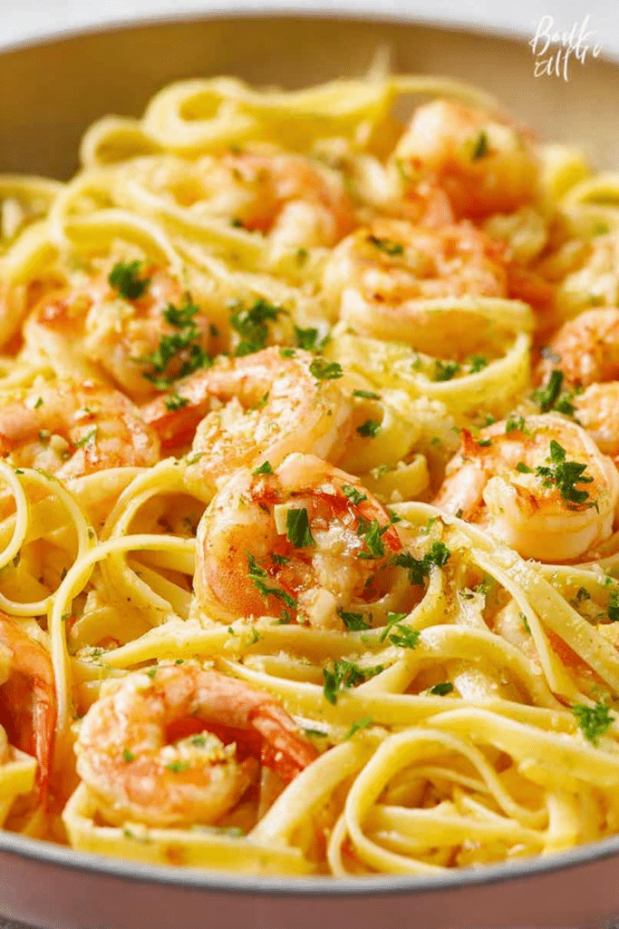 Garlic butter shrimp pasta served on a plate with lemon and parsley garnish