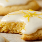 Delicious glazed lemon cookies topped with lemon glaze and garnished with lemon zest and slices, on a decorative plate.