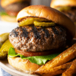 Freshly grilled hamburger patties with herbs on the grill.