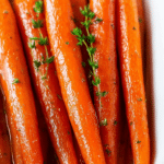 Close-up of honey roasted carrots garnished with parsley on a plate