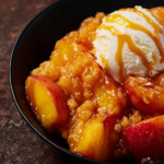Slice of Hot Honey Peaches and Cream Dump Cake on a plate with vanilla ice cream and Hot Honey drizzle
