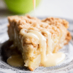 Irish Apple Cake served with fresh apples and cinnamon sticks, dusted with confectioner's sugar on a wooden table.