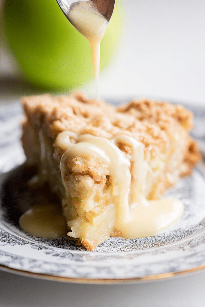 Irish Apple Cake served with fresh apples and cinnamon sticks, dusted with confectioner's sugar on a wooden table.