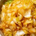 Close-up of golden sautéed cabbage in a skillet with onions and smoked paprika