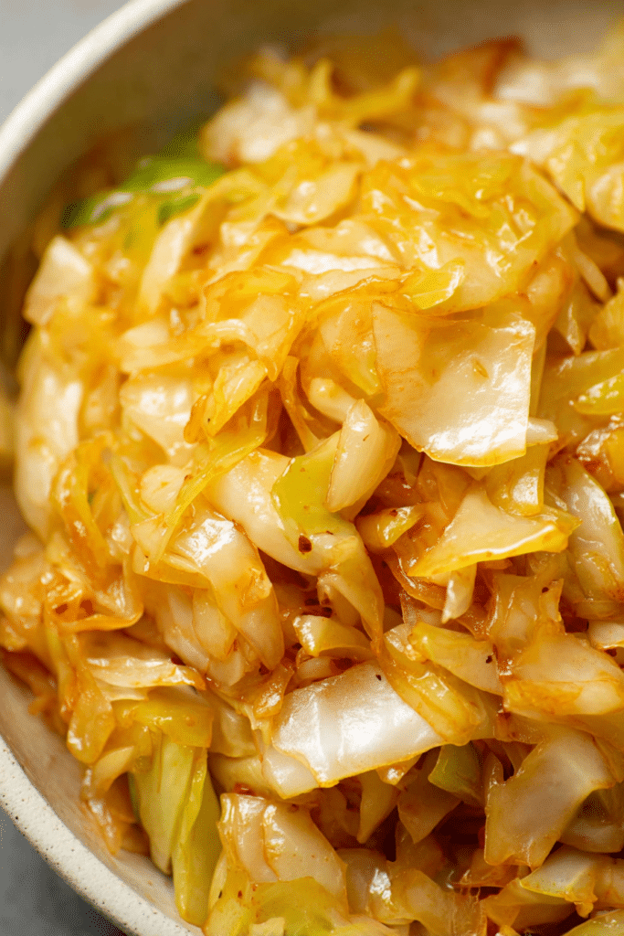 Close-up of golden sautéed cabbage in a skillet with onions and smoked paprika