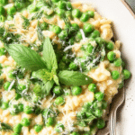 Bowl of spring pea risotto with herbs and lemon zest, highlighting fresh green peas.