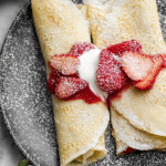 Delicious strawberry crepes with fresh strawberries and whipped cream, perfect for breakfast or dessert.