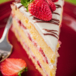 Freshly baked strawberry layer cake adorned with strawberries and chocolate on a rustic table.