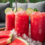 Refreshing watermelon slushie in a glass, garnished with mint and lime for summer enjoyment.
