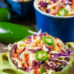 Cajun Honey Jalapeño Slaw in a vibrant bowl, garnished with fresh jalapeños.