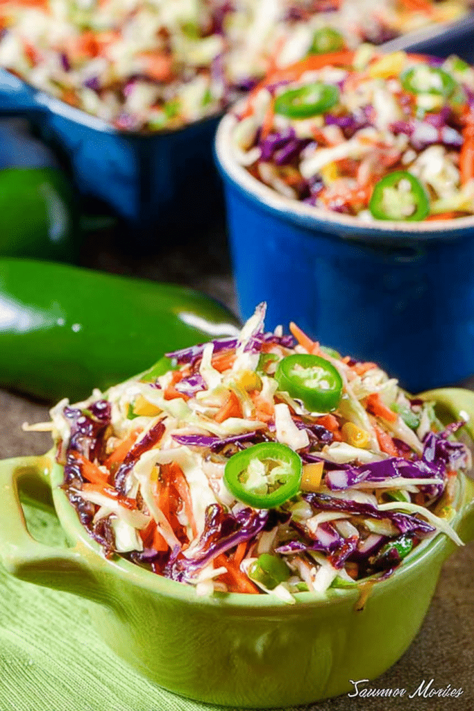 Cajun Honey Jalapeño Slaw in a vibrant bowl, garnished with fresh jalapeños.