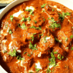 Delicious chicken tikka masala served with naan and basmati rice, garnished with fresh coriander.