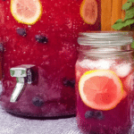 Frosty blueberry lemonade in a glass with blueberries and lemon slice on a summer table.