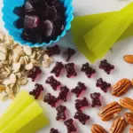 Healthy blueberry-beet gummies in a bowl with fresh blueberries and beets