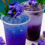 Lychee Italian Soda with Blue Tea Mocktail served with a lime slice on a sunlit table.