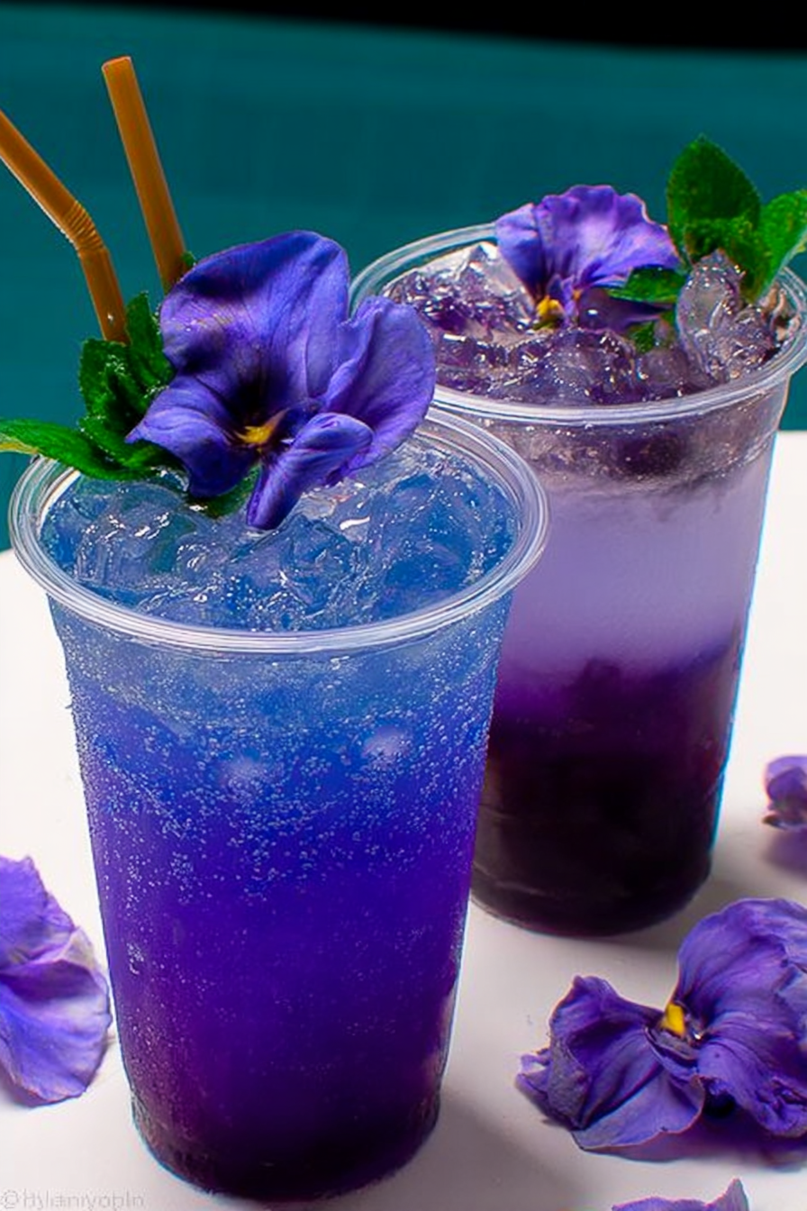 Lychee Italian Soda with Blue Tea Mocktail served with a lime slice on a sunlit table.
