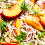 Nectarine and fennel salad with almonds and herbs on a white plate