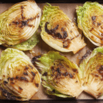 Oven baked cabbage wedge with mustard sauce garnished with parsley on a plate.