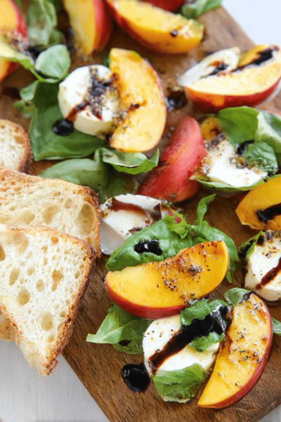 Vibrant Peach-Basil Caprese Salad Stacks on a wooden table with fresh basil and balsamic glaze