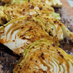 Plated spicy baked cabbage garnished with herbs.