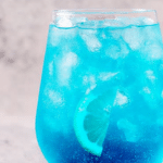 Refreshing blue raspberry energy drink in a tall glass with ice and garnish, perfect for energizing hydration.