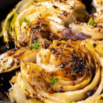 Close-up of roasted cabbage wedges drizzled with hot honey on a rustic table