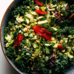 Roasted peanut kale crunch salad with vibrant kale, cabbage, peanuts, and fresno peppers in a bowl.