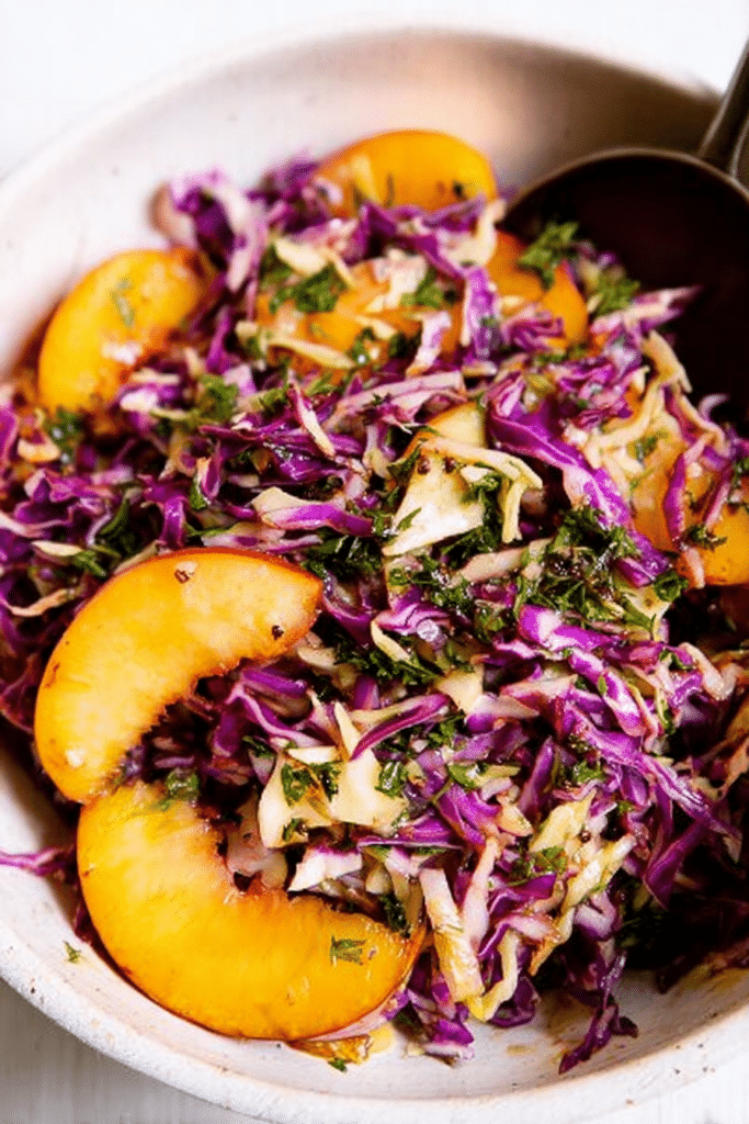 Colorful summer slaw with peaches and parsley in a bowl, garnished with sunflower seeds