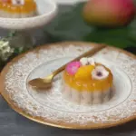 Close-up of Thai mango coconut jelly in glass cups garnished with mango pieces and coconut flakes.